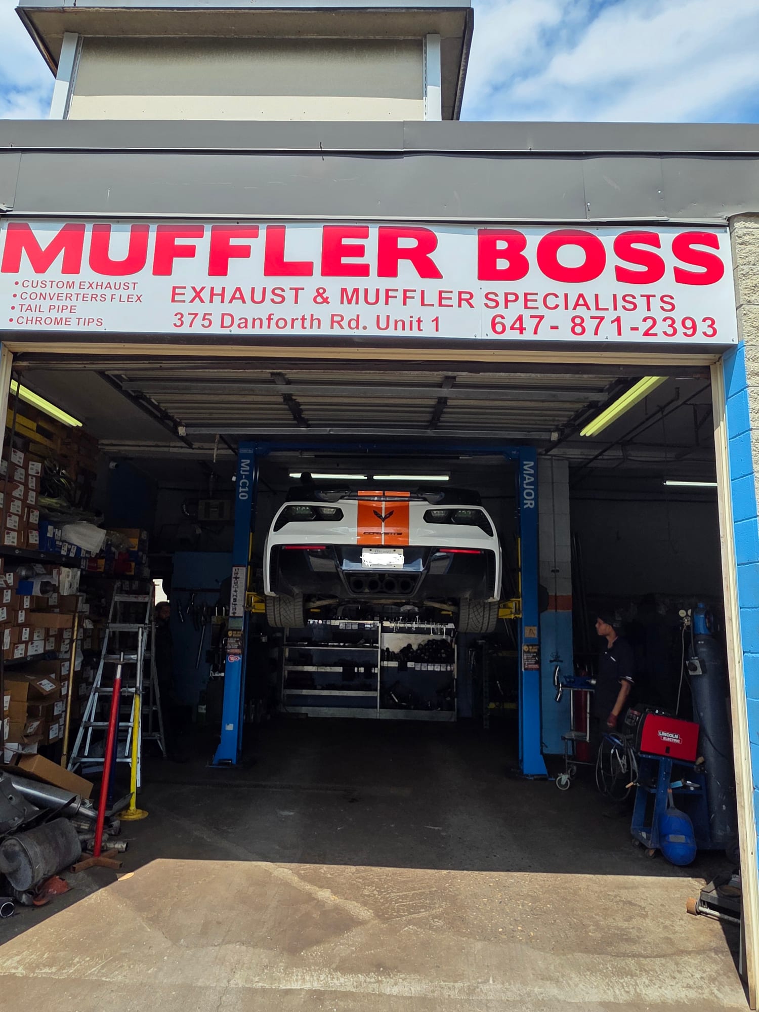 The Boss Tire muffler and exhaust bay, a car up on the lift