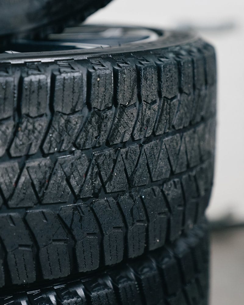 A stack of new and used tires with detailed tread at Boss Tire