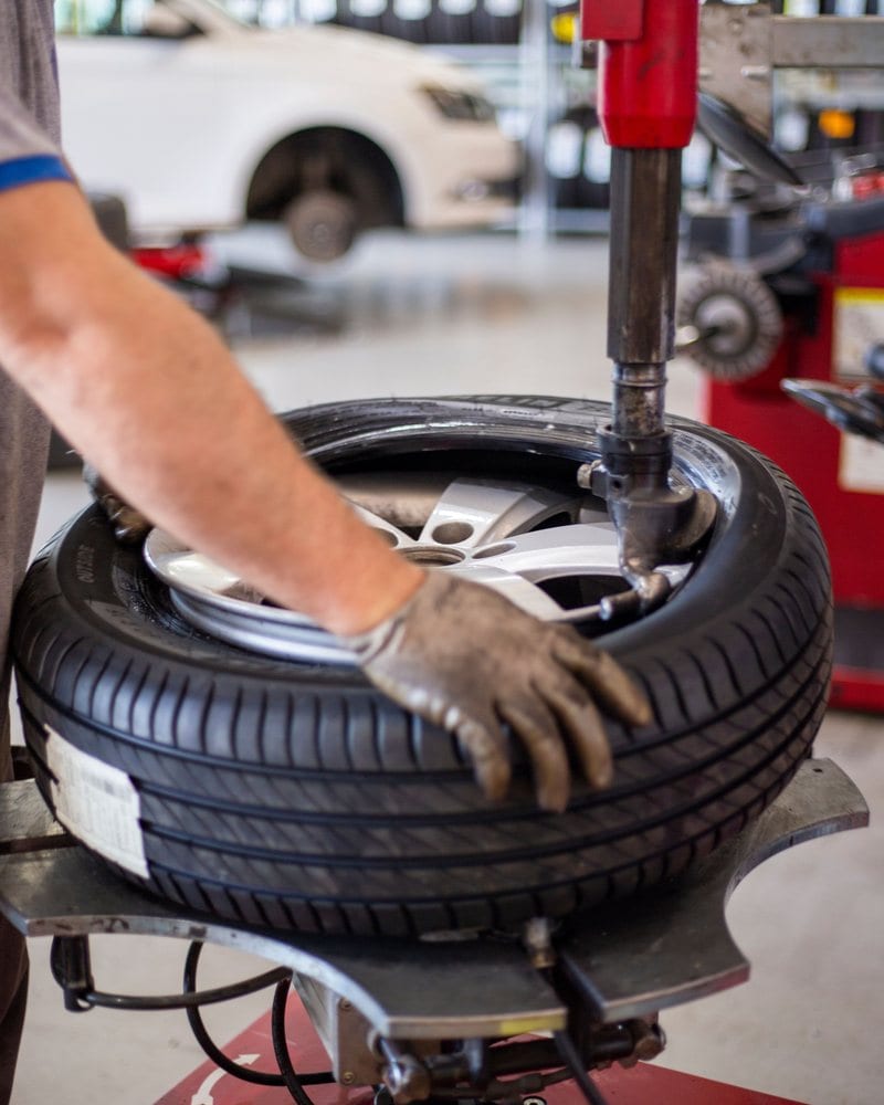 Technician mounting a tire on the changer during a seasonal changeover
